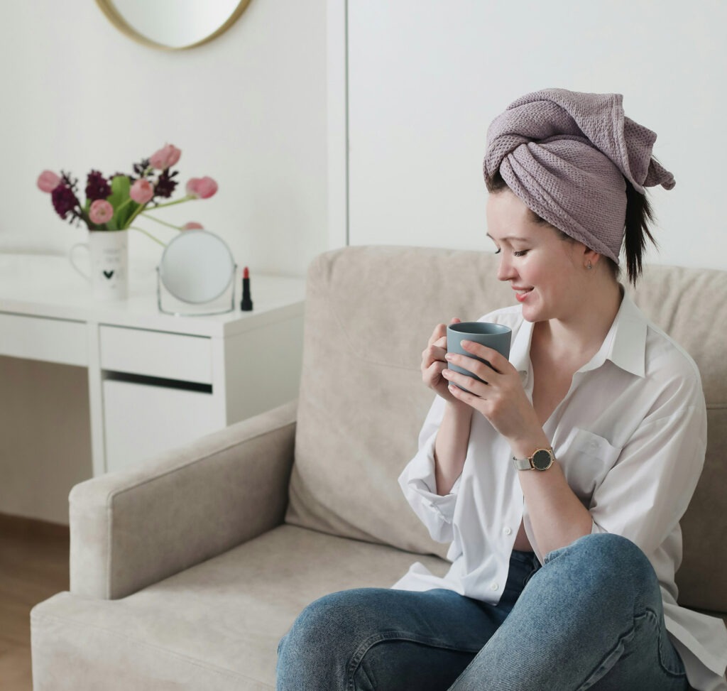 Frau auf Sofa trinkt Kaffee